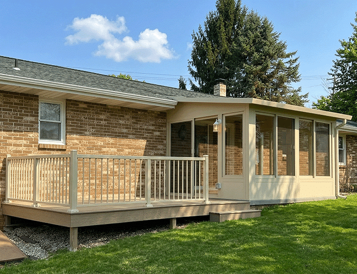 beige-deck-sunroom-ohio A beige flat roof sunroom with a matching composite deck